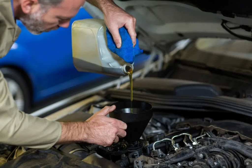 Persona revisando el nivel y estado del aceite de un auto usado antes de comprarlo