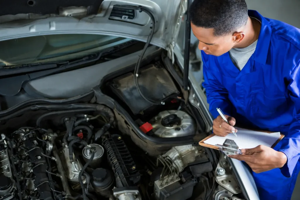 Técnico inspeccionando un auto seminuevo en el taller de un concesionario