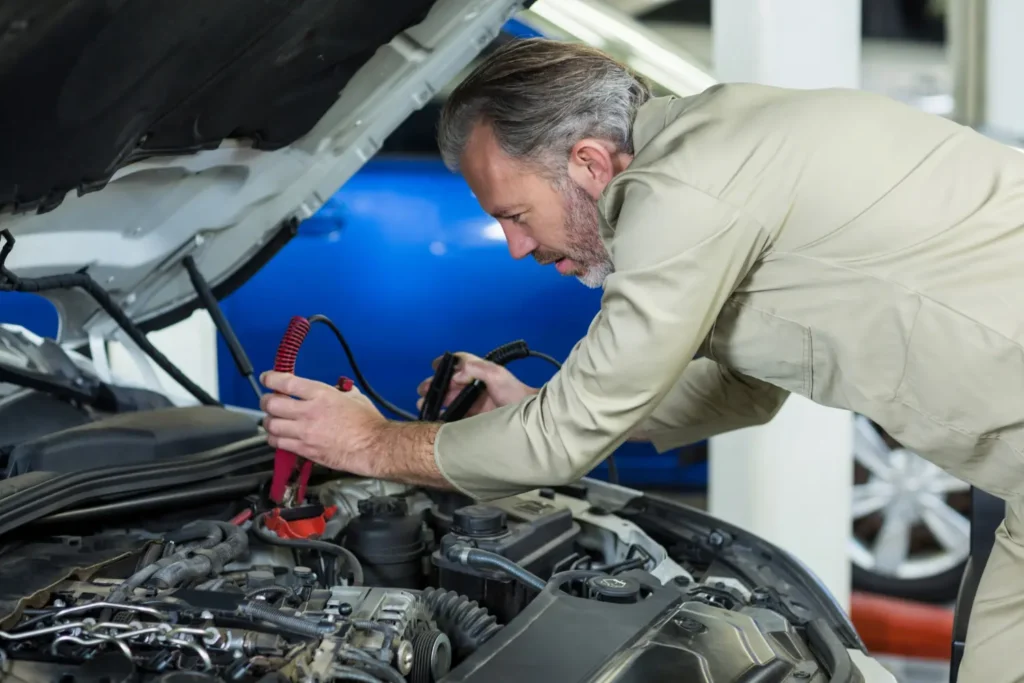 Técnico revisando la batería de un auto usado durante una inspección de mantenimiento